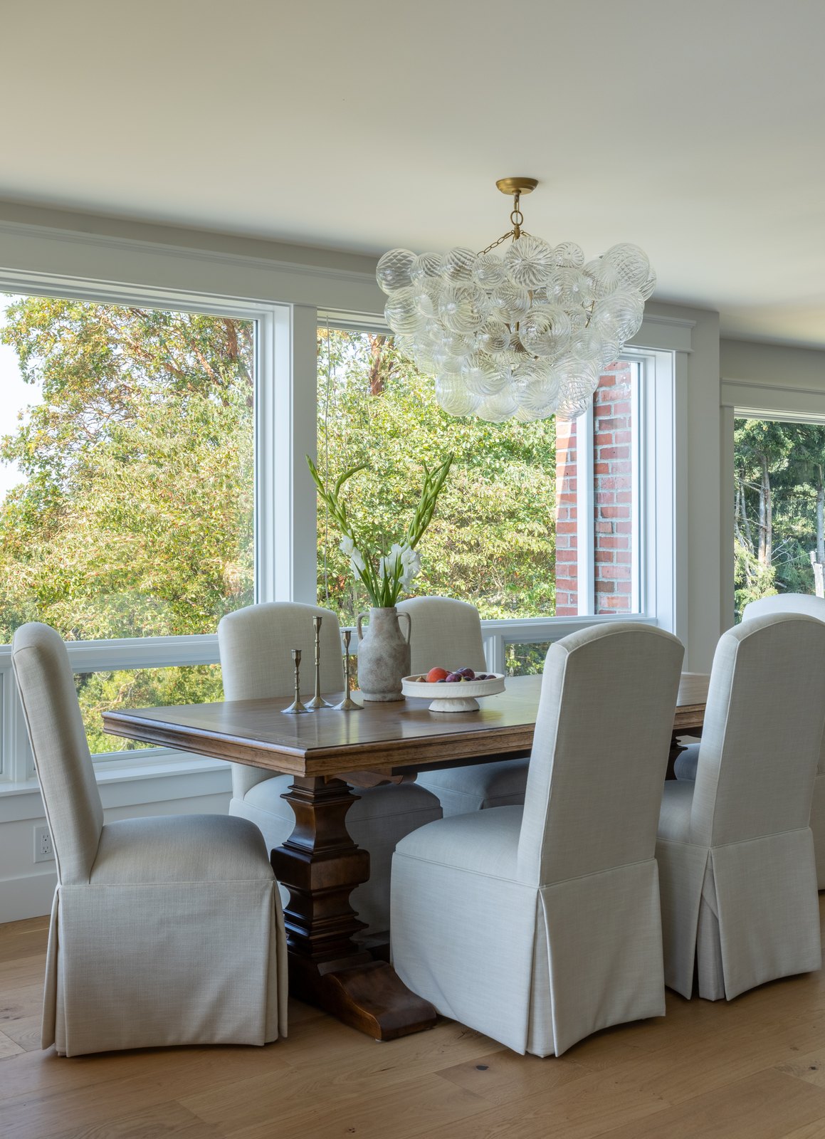 Dining room with slipcovered chairs and a glass chandelier