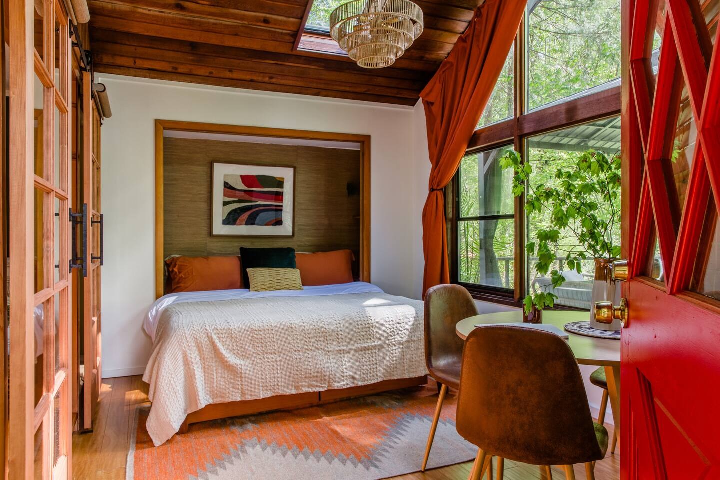 Sunroom bedroom with cedar ceiling and orange curtains