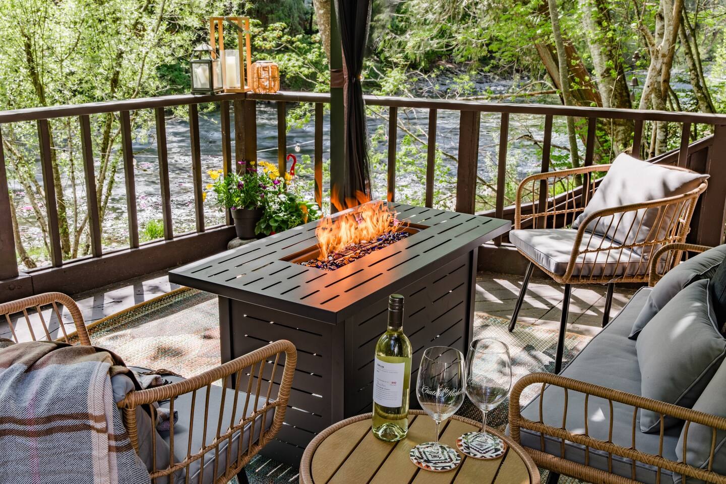 Riverside deck with a fire table and woven chairs